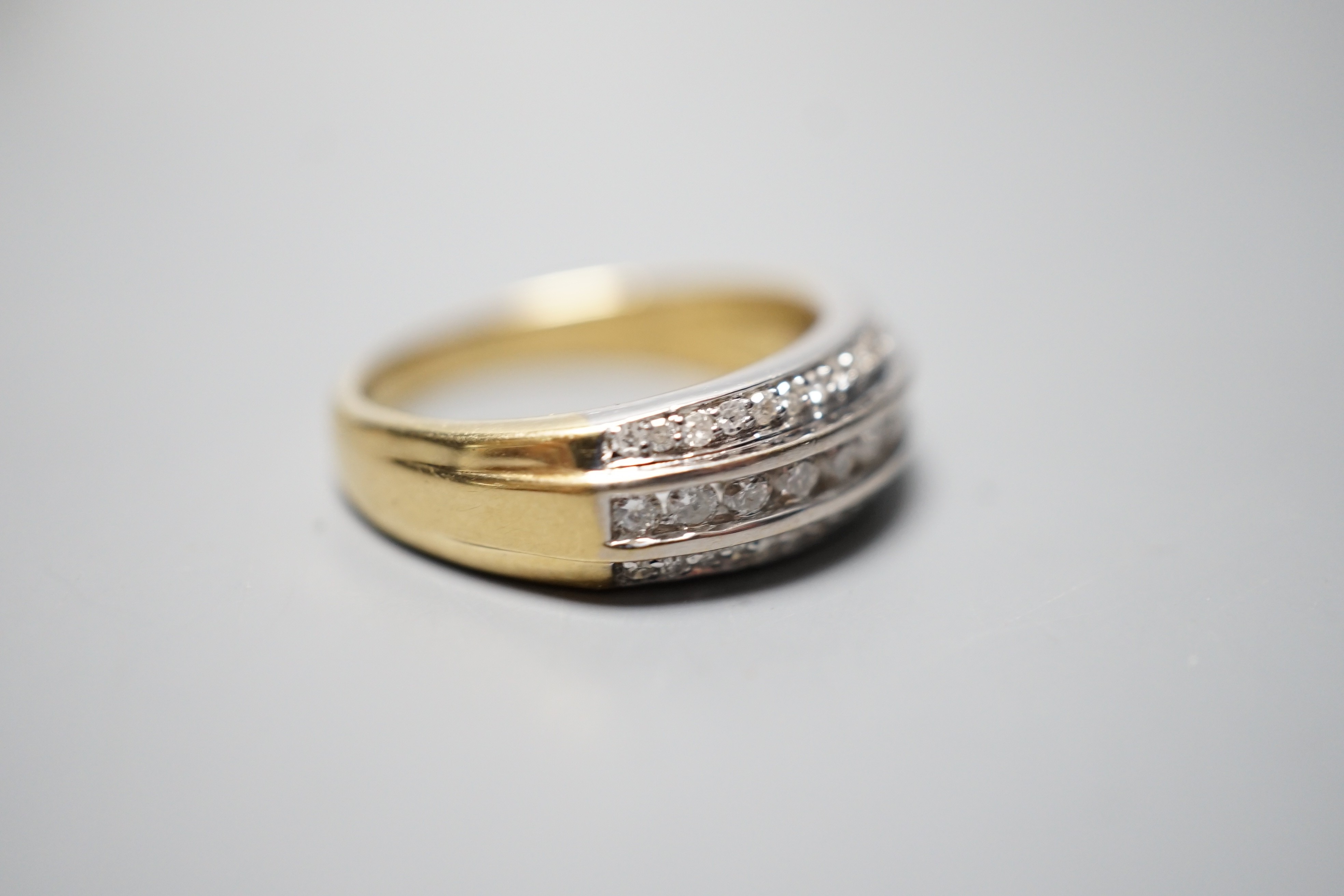 A modern 18ct gold and three row diamond set half eternity ring, size P, gross weight 6.8 grams.